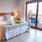 Bedroom with outside decking area, at Agulhas House accommodation, South Africa.