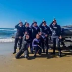 Group of divers on shore posing by the Agulhas Diving RIB, in South Africa.