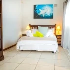 Double bed in the Agulhas House accommodation, with shelving to places luggage.