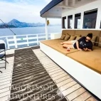View of the upper deck seating area with lounge area, and casual dining sets, on Komodo Aggressor, Indonesia.