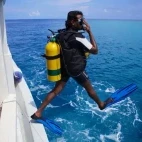 Diver jumping into the water in the Maldives