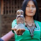 Woman with a hand-crafted owl at Napo Cultural Centure Lodge, Ecuador.