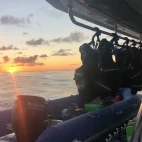 Sunset view of the support RIB on Aqua Tiki III, French Polynesia.