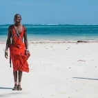 Masai warrior walking along a beach in Zanzibar