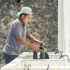 Man utilising Alor Tanapi Dive Centre's rinse tanks to rinse a buoyancy aid.
