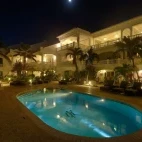 View of the pool and Belmar Oceanfront Apartments at night.