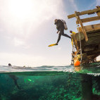 Divers jumping into water at Breakers Diving and Surfing Lodge, Egypt.