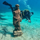 Diver exploring a statue underwater in Malta.