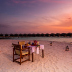Outdoor dining area at sunset at Filitheyo Resort, The Maldives