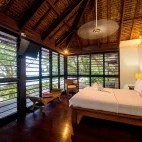 A luxury beachfront fare bedroom, with fan and TV.