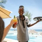 Guest being served cocktails at Sunshine Marine Lodge, Zanzibar.