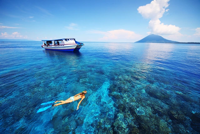 Snorkeller & boat in Bunaken National Marine Park, Indonesia