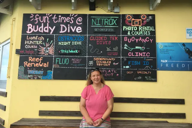 Woman sat in front of dive school activities board