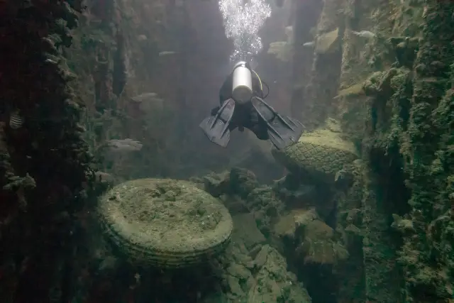 Diver swimming through one of SS President Coolidge's cargo holds.