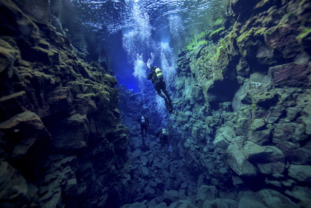 Diver in Silfra, Iceland, swimming between two tectonic plates